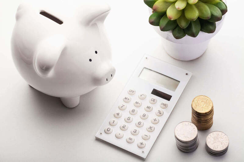 Piggy bank with calculator and change next to it